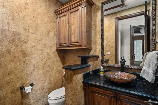 a view of a bathroom with a granite countertop sink and a mirror