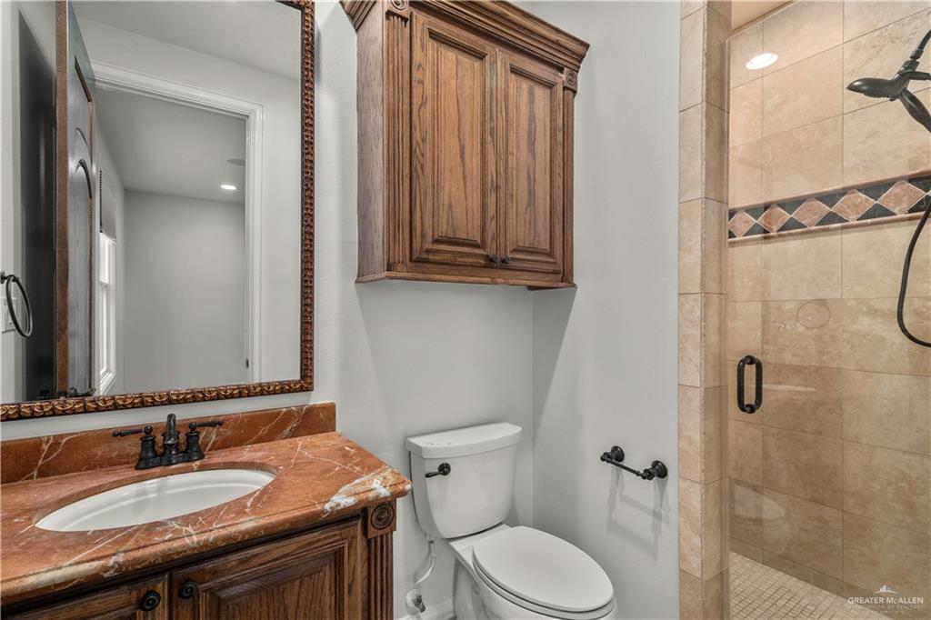 4405 South "H" Street McAllen, TX 78503 - Photo 26 of 33 a bathroom with a granite countertop toilet sink and mirror