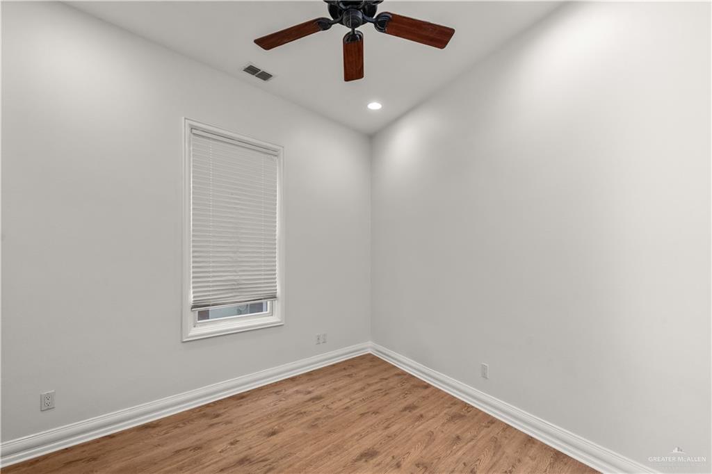 4405 South "H" Street McAllen, TX 78503 - Photo 27 of 33 an empty room with wooden floor ceiling fan and windows