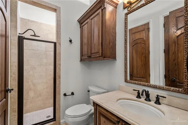 a bathroom with a granite countertop sink toilet and mirror