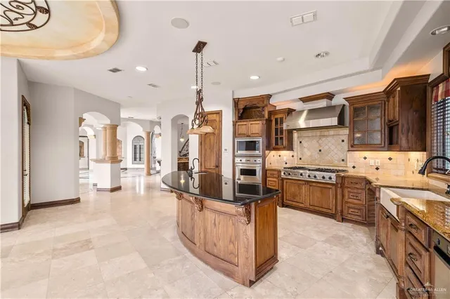 a large kitchen with stainless steel appliances a stove a sink dishwasher and cabinets with wooden floor