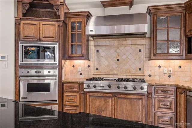 a kitchen with stainless steel appliances granite countertop a stove and a microwave