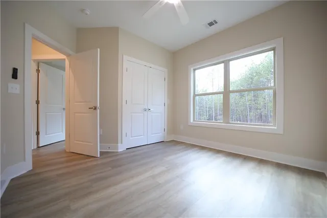 an empty room with wooden floor and windows