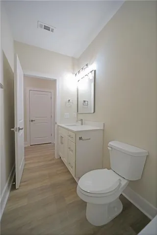 a bathroom with a toilet sink vanity and mirror
