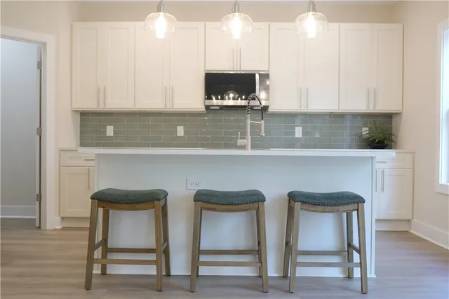 a kitchen with cabinets and chairs