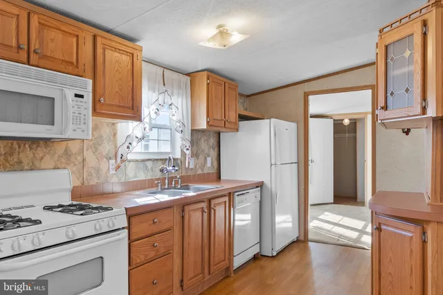 a kitchen with granite countertop a refrigerator stove and sink