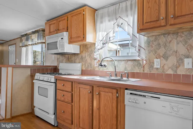 a kitchen with stainless steel appliances granite countertop a sink and cabinets with wooden floor