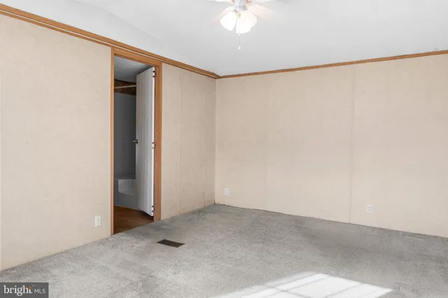 an empty room with a ceiling fan and a window