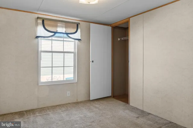 an empty room with windows and closet