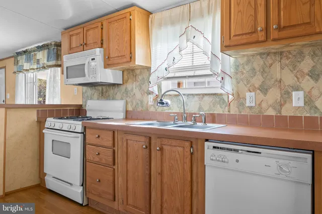 a kitchen with stainless steel appliances granite countertop a sink and dishwasher a stove with wooden cabinets