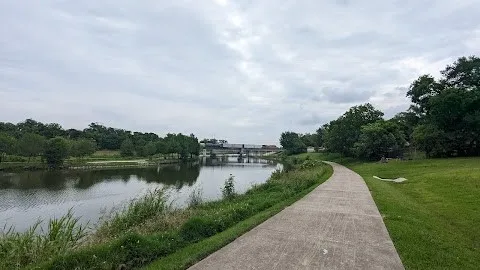 a view of a lake with a yard and large trees