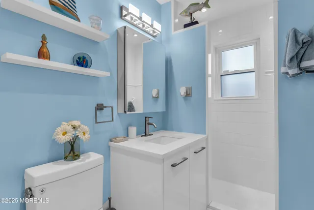 a bathroom with a sink a toilet and a mirror