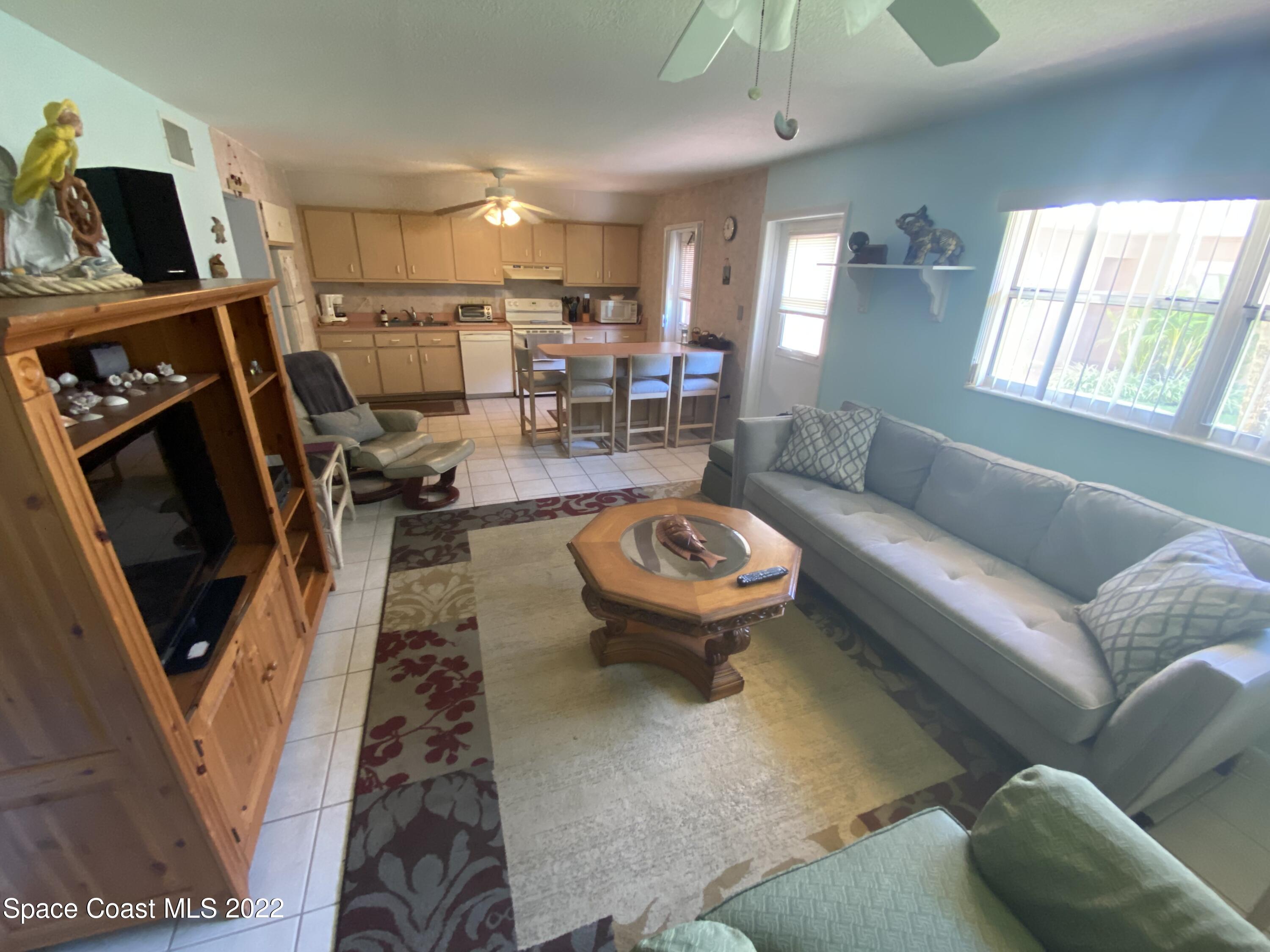 610 Jefferson Avenue, Unit 2 Cape Canaveral, FL 32920 - Photo 6 of 8 a living room with furniture and a flat screen tv