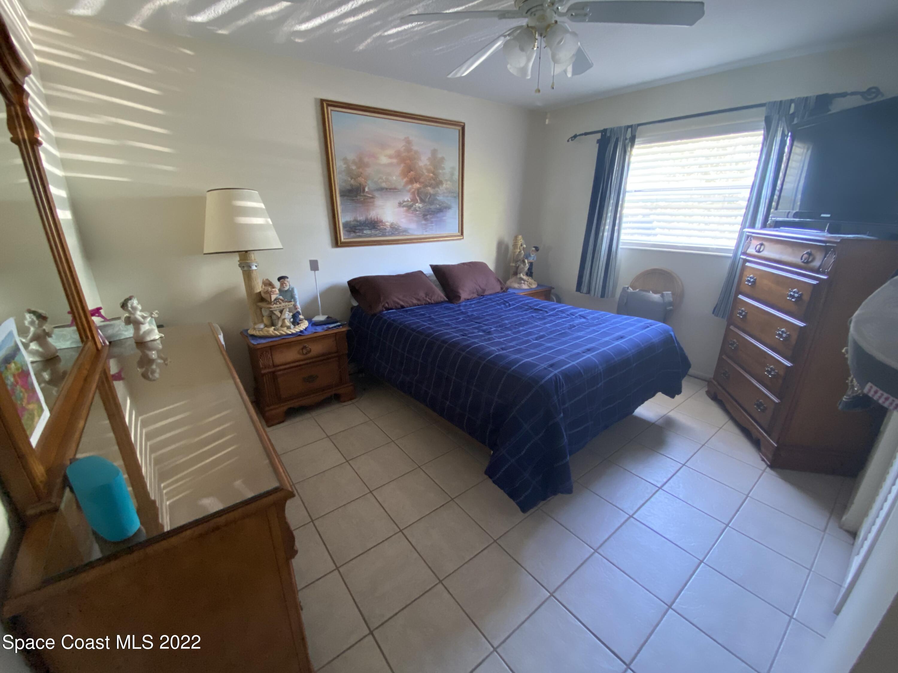 610 Jefferson Avenue, Unit 2 Cape Canaveral, FL 32920 - Photo 8 of 8 a bedroom with a bed and a chandelier