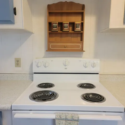 a dining hall with stainless steel appliances granite countertop a refrigerator and a stove top oven