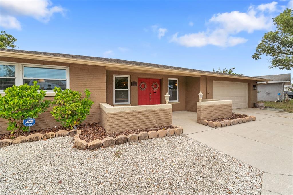 7517 Scottie Drive Port Richey, FL 34668 - Photo 1 of 1 a front view of a house with a yard and garage