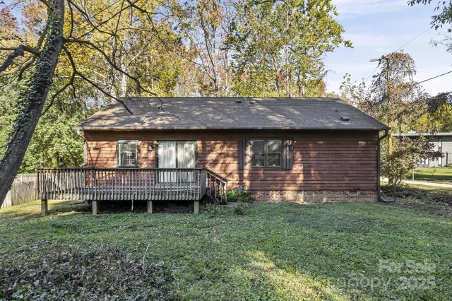 a view of a house next to a yard with wooden fence