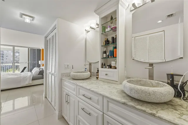 a en suite bathroom with a granite countertop sink and a mirror
