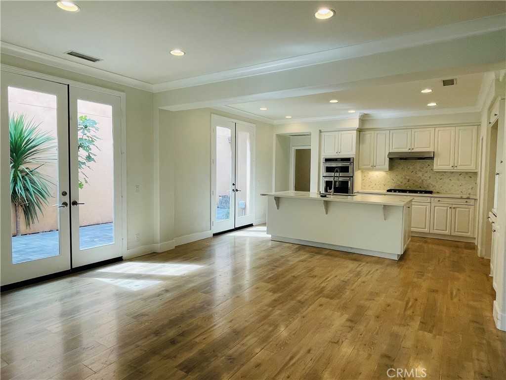173 Sanctuary Irvine, CA 92620 - Photo 7 of 24 a living room with stainless steel appliances kitchen island granite countertop a stove and a view of living room