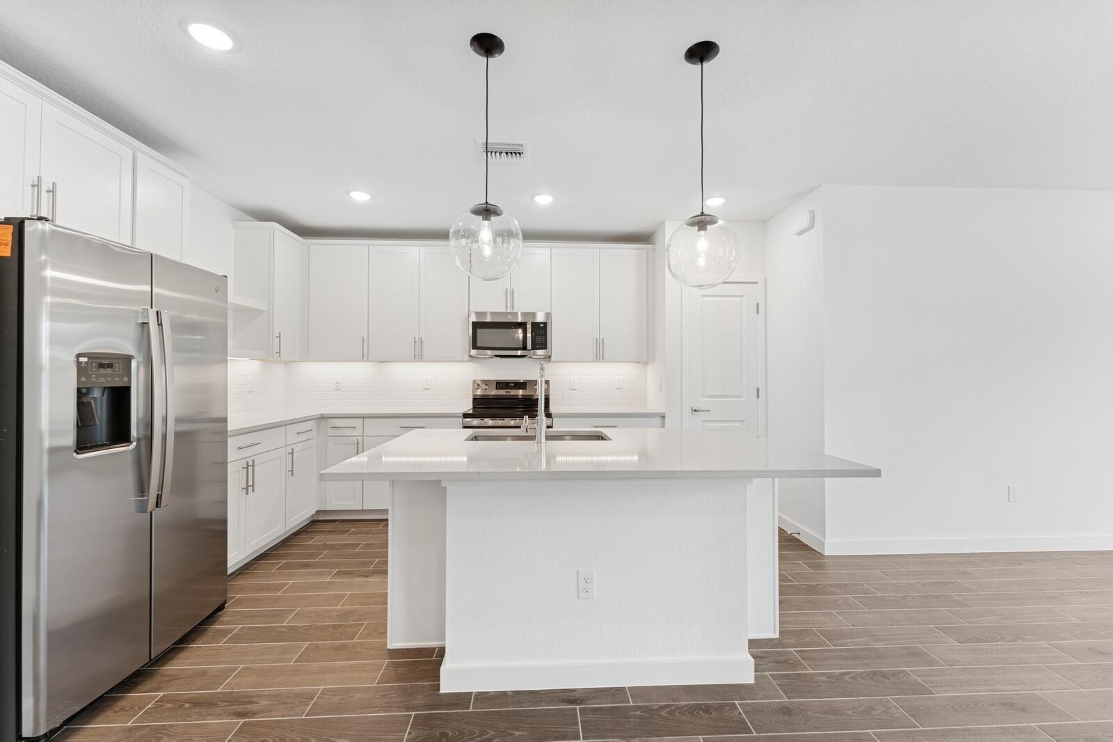 9740 Apollo Avenue, Unit 2 Fort Pierce, FL 34945 - Photo 3 of 18 a kitchen with kitchen island a sink stainless steel appliances and cabinets