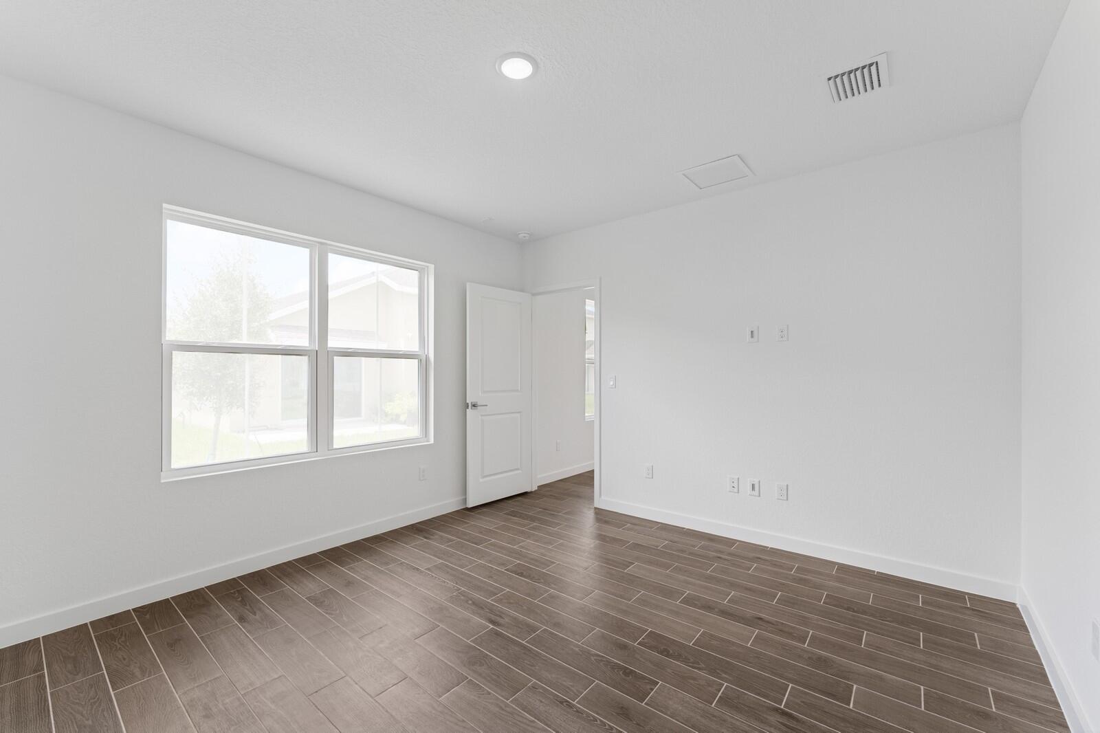 9740 Apollo Avenue, Unit 2 Fort Pierce, FL 34945 - Photo 7 of 18 an empty room with wooden floor and windows