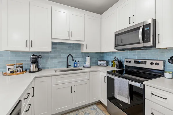 a kitchen with cabinets appliances a sink and a counter top