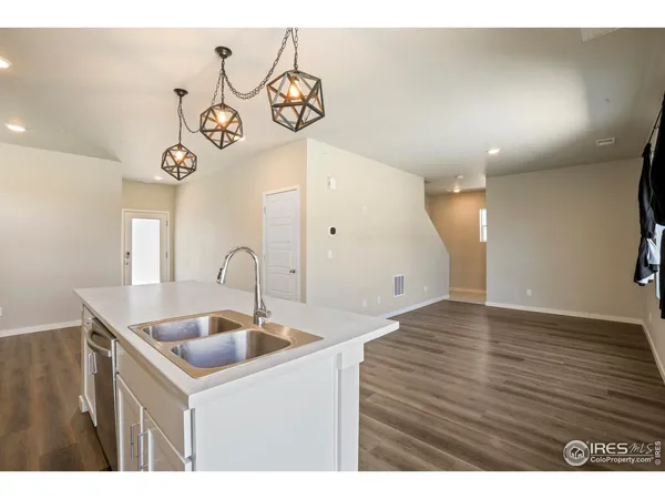 a kitchen with kitchen island a sink and a stove with wooden floor