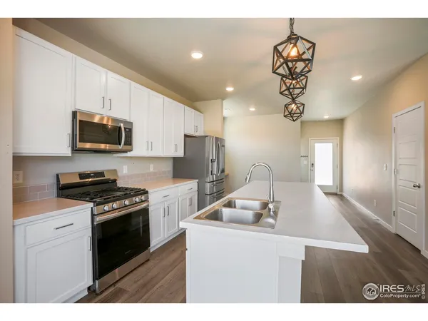 a kitchen with a sink a microwave a stove and refrigerator