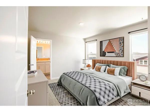 a bedroom with a bed painting on wall and a large window