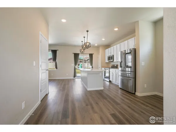 a view of a kitchen and an entryway with wooden floor
