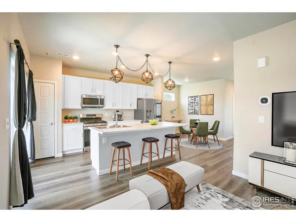 a large kitchen with a table chairs refrigerator and a sink