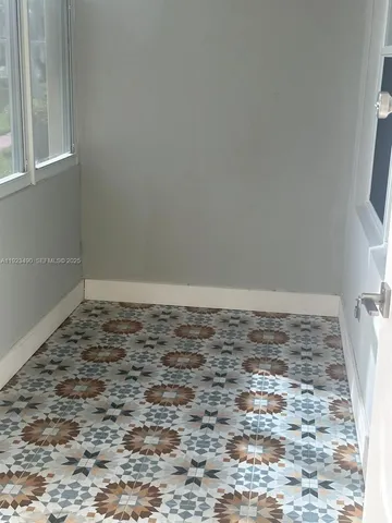 a view of empty room with window and wooden floor