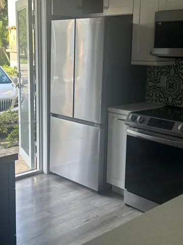 a kitchen with a refrigerator stove and a microwave oven