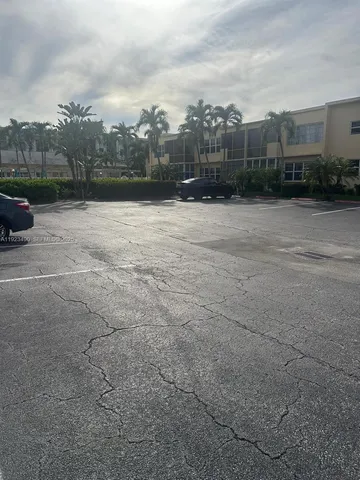 a view of empty room with wooden floor and a window