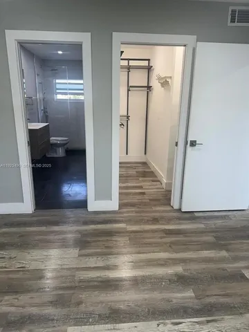 a view of a hallway view with wooden floor and living room