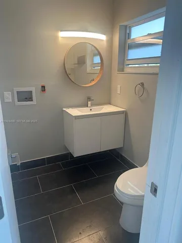 a bathroom with a toilet a sink and mirror