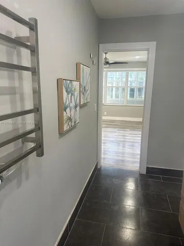 a view of a hallway with wooden floor and a window