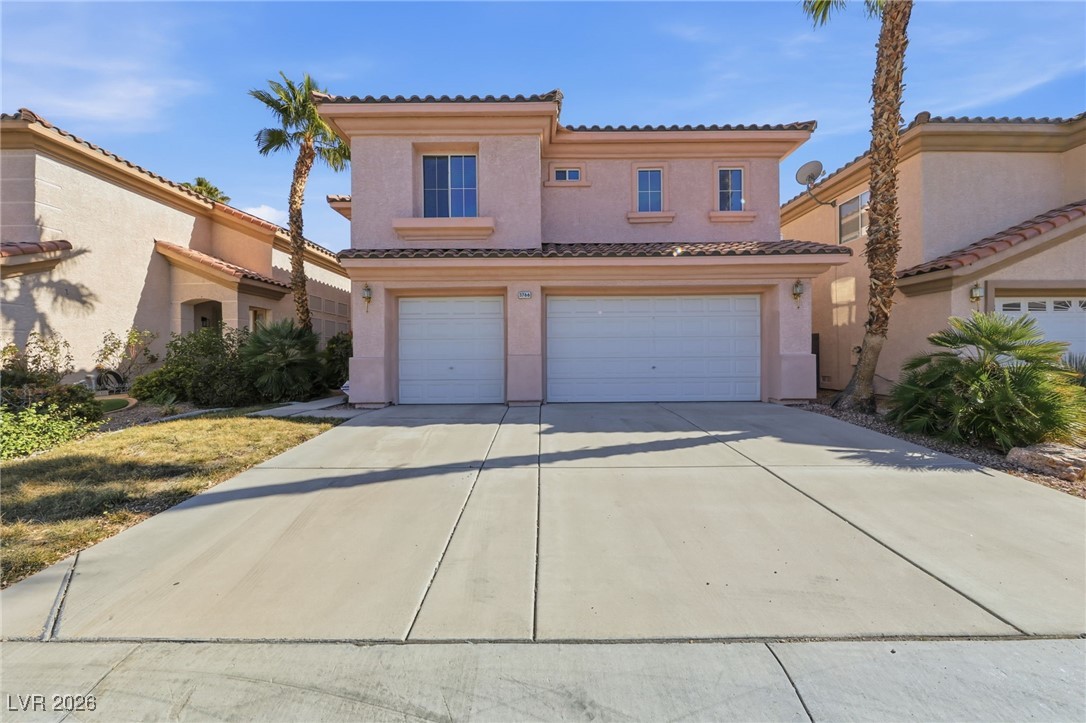 Mediterranean / spanish-style house with an attached garage, driveway, stucco siding, and a tiled roof