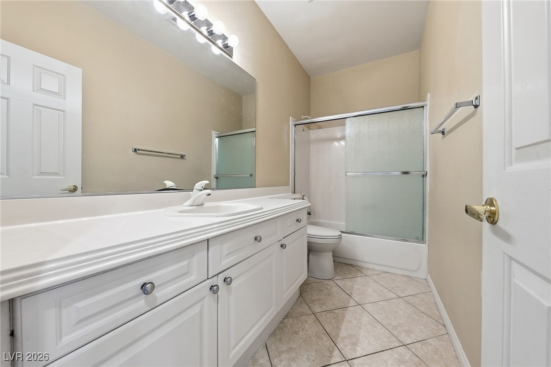 3766 Port Ritchey Street Las Vegas, NV 89147 - Photo 21 of 50 Full Bathroom featuring bath / shower combo with glass door, vanity, and light tile patterned floors