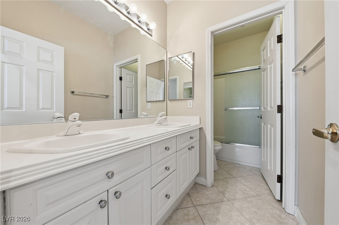 3766 Port Ritchey Street Las Vegas, NV 89147 - Photo 22 of 50 Full Bathroom featuring bath / shower combo with glass door, double vanity, and light tile patterned flooring