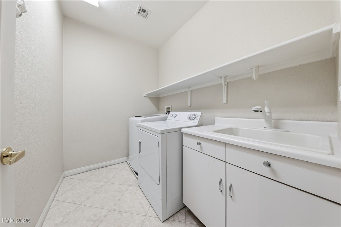3766 Port Ritchey Street Las Vegas, NV 89147 - Photo 25 of 50 Laundry area featuring separate washer and dryer, light tile patterned floors, and cabinet space