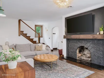 a living room with furniture a flat screen tv and a fireplace