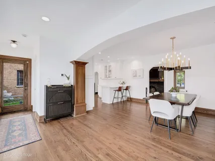 a dining room with furniture a chandelier and wooden floor