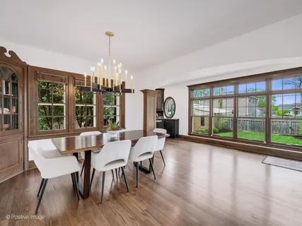 a dining room with furniture a chandelier and wooden floor