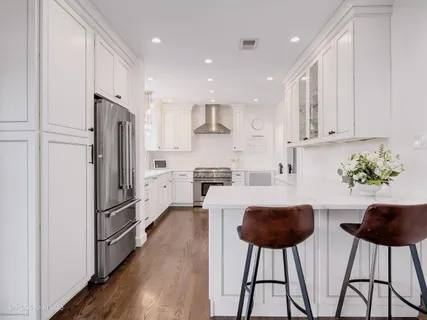 a kitchen with stainless steel appliances granite countertop a refrigerator and a stove top oven