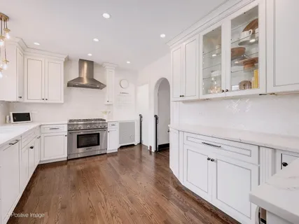 a kitchen with white cabinets and appliances