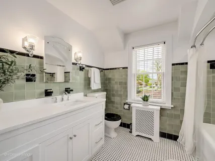 a bathroom with a sink a toilet a mirror and shower
