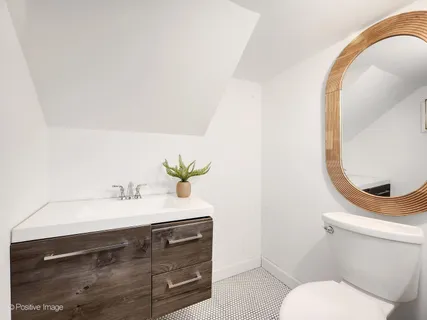a bathroom with a sink vanity mirror and toilet