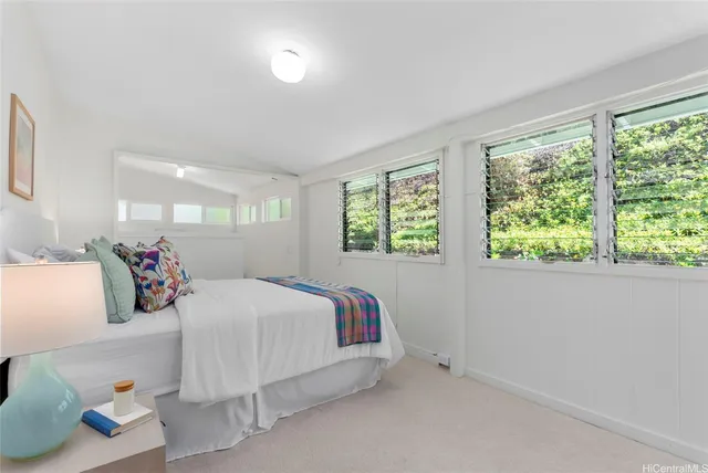 a bedroom with a large bed and a lamp with window