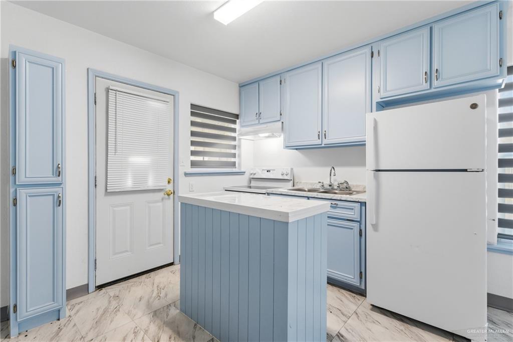 109 Ash Street, Unit B Donna, TX 78537 - Photo 4 of 14 a kitchen with a refrigerator sink stove and cabinets